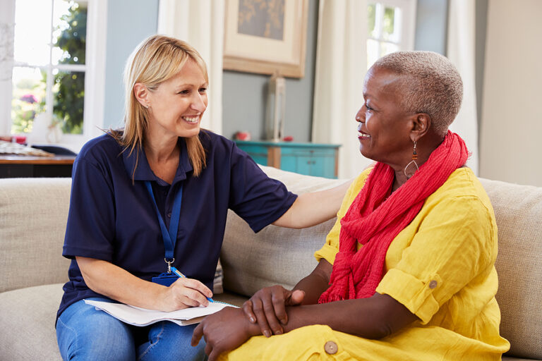 Female social worker talking with elderly female woman